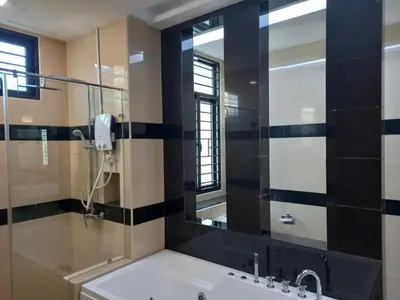 a bathroom with a tub and a mirror at Pearl Residences Sleep 27 in Batu Ferringhi