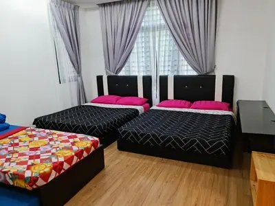 a bedroom with two beds and a window at Pearl Residences Sleep 27 in Batu Ferringhi