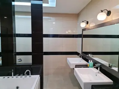 a bathroom with two sinks and two mirrors at Pearl Residences Sleep 27 in Batu Ferringhi