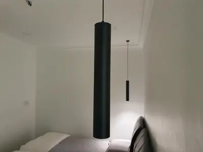 a black chandelier hanging over a bed in a room at Number A Homestay in Raub