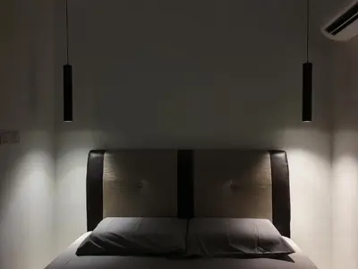 a bed in a bedroom with two lights above it at Number A Homestay in Raub