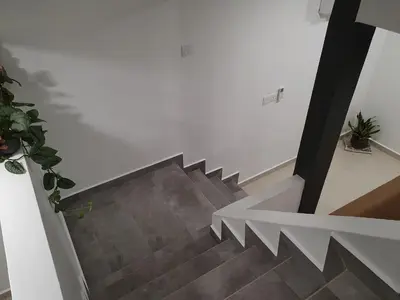 a staircase in a house with a white wall at Number A Homestay in Raub