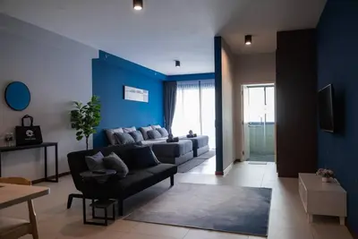a living room with a couch and a blue wall at Deluxe Seaview Suite Twin Bed by The Only Bnb in Tanjong Tokong