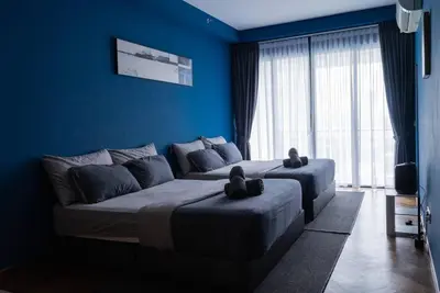a blue bedroom with two beds with teddy bears on them at Deluxe Seaview Suite Twin Bed by The Only Bnb in Tanjong Tokong