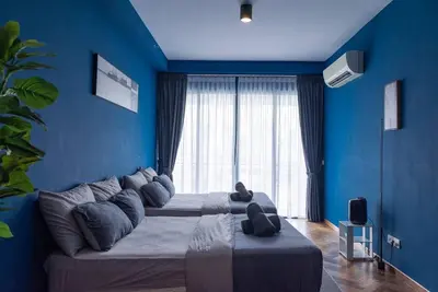 a blue room with a large bed in front of a window at Deluxe Seaview Suite Twin Bed by The Only Bnb in Tanjong Tokong