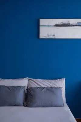 a blue wall with a bed with two blue pillows at Deluxe Seaview Suite Twin Bed by The Only Bnb in Tanjong Tokong