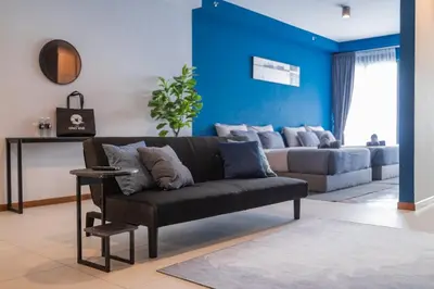 a living room with a couch and a blue wall at Deluxe Seaview Suite Twin Bed by The Only Bnb in Tanjong Tokong