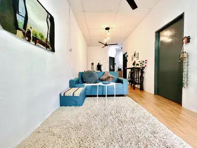 a living room with a blue couch and a rug at Cozy 18 Entire 3 Bedroom @Alma Bukit Mertajam in Bukit Mertajam