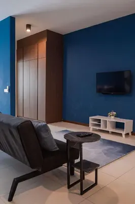 a living room with a couch and a blue wall at Deluxe Seaview Suite Twin Bed by The Only Bnb in Tanjong Tokong