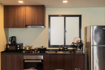 a kitchen with a sink and a refrigerator at Deluxe Seaview Suite Twin Bed by The Only Bnb in Tanjong Tokong