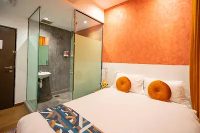 a bedroom with a bed and a glass shower at Apollo Inn in George Town