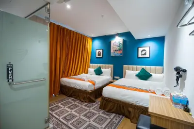 two beds in a room with blue walls at Apollo Inn in George Town