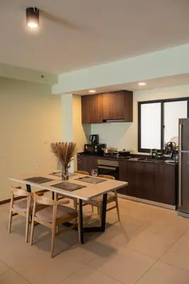 a kitchen with a table with chairs and a refrigerator at Deluxe Seaview Suite Twin Bed by The Only Bnb in Tanjong Tokong