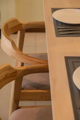a wooden chair sitting next to a table at Deluxe Seaview Suite Twin Bed by The Only Bnb in Tanjong Tokong