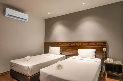a room with two beds and a wall at Q Collection Macalister formerly known as Apple Hotel Penang in George Town