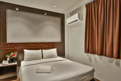 a bedroom with a white bed and a window at Q Collection Macalister formerly known as Apple Hotel Penang in George Town