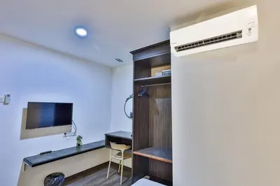 a room with a desk and a tv in a room at Q Collection Macalister formerly known as Apple Hotel Penang in George Town