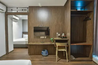 a room with a bed and a desk with a television at Q Collection Macalister formerly known as Apple Hotel Penang in George Town