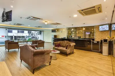 a lobby with couches and chairs and a bar at Q Collection Macalister formerly known as Apple Hotel Penang in George Town
