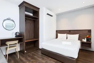 a bedroom with a bed and a desk and a chair at Q Collection Macalister formerly known as Apple Hotel Penang in George Town
