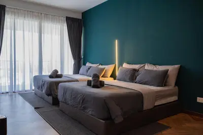 two beds in a bedroom with a blue wall at Family Seaview Suite with 3 Rooms by The Only Bnb in Tanjong Tokong