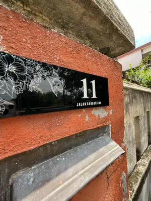a sign on the side of a brick building at Solehah Homestay in Seri Iskandar