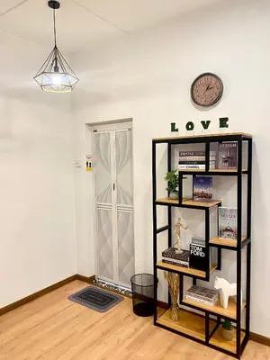 a room with a clock and a shelf with books at comfy 3-bedrooms with family karaoke Max-10pax in Ipoh