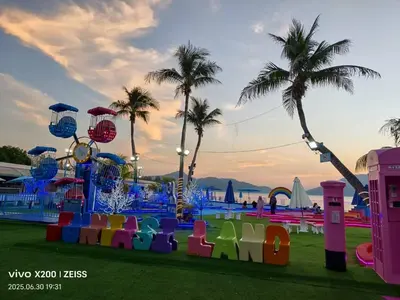 a park with a playground with colorful chairs and palm trees at Omari Marina Island Homestay Lumut in Lumut