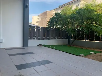 a patio with a yard with a fence and a palm tree at Omari Marina Island Homestay Lumut in Lumut