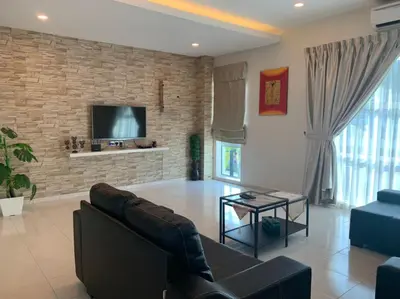 a living room with a couch and a tv on a brick wall at Omari Marina Island Homestay Lumut in Lumut