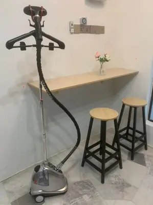 a vacuum cleaner in a room with a table and stools at Kota Permai Free n Easy Interior Bukit Mertajam in Bukit Mertajam