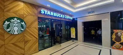 a starbucks store with a sign on the wall at LS Mansion One in George Town
