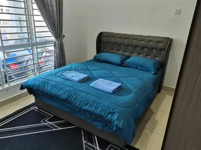 a bedroom with a bed with blue sheets and a window at Abah StayCation in Sungai Besar