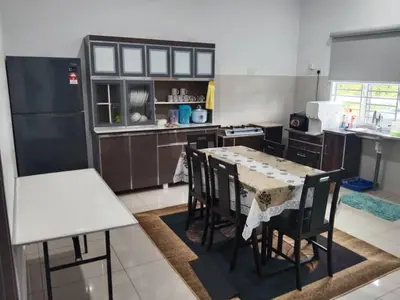 a kitchen with a table and chairs in it at Abah StayCation in Sungai Besar