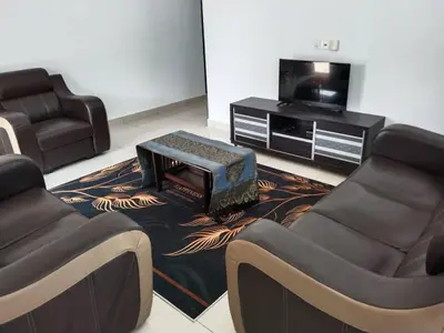 a living room with two chairs and a tv at Abah StayCation in Sungai Besar