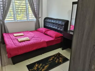 a bedroom with a bed with pink sheets and a mirror at Abah StayCation in Sungai Besar