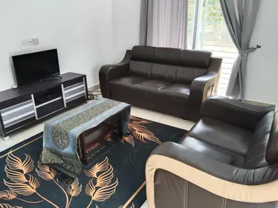 a living room with a leather couch and a chair at Abah StayCation in Sungai Besar