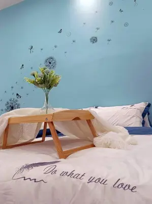 a bed with a vase of flowers on top of it at De cozy 5.0 Double storey (10-16 pax ++) in Ipoh