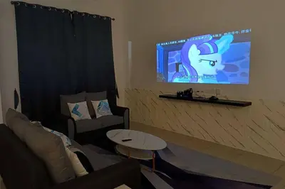 a living room with a tv with a cat on the screen at De cozy 5.0 Double storey (10-16 pax ++) in Ipoh