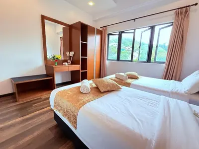 a bedroom with two beds and a mirror at Nova Mountain n Sunrise view Hilltop Hotel Apartment in Cameron Highlands in Cameron Highlands
