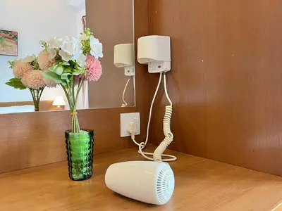 a phone and a vase with flowers on a table at Nova Mountain n Sunrise view Hilltop Hotel Apartment in Cameron Highlands in Cameron Highlands