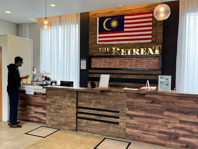 a man standing at a counter with an american flag at Nova Mountain n Sunrise view Hilltop Hotel Apartment in Cameron Highlands in Cameron Highlands