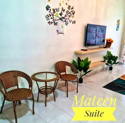a living room with chairs and a table and a tv at M Suite in Tanah Rata