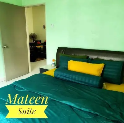 a bed with green and yellow pillows in a room at M Suite in Tanah Rata