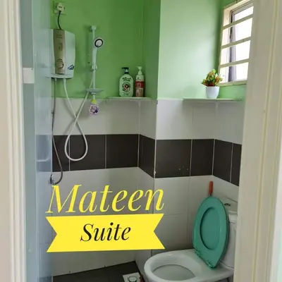 a bathroom with a toilet with a green and yellow sign at M Suite in Tanah Rata