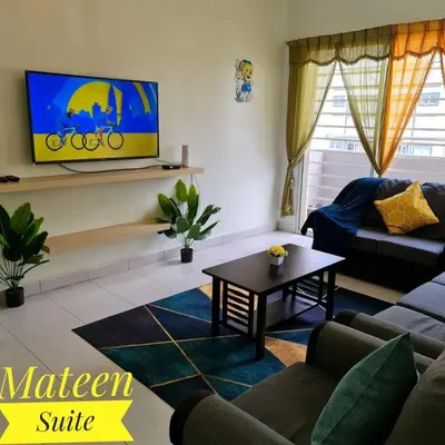 a living room with a couch and a tv on a wall at M Suite in Tanah Rata