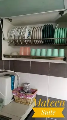 a kitchen shelf with plates and bowls on it at M Suite in Tanah Rata