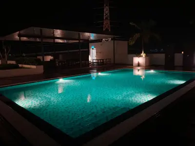 a swimming pool lit up at night at Comfortable18 3R2B 7pax Meritus Perai in Perai