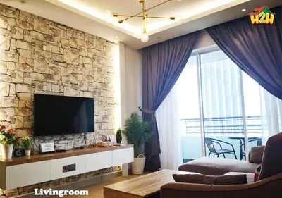a living room with a tv on a stone wall at H2H - CY15 @ Majestic Ipoh in Ipoh