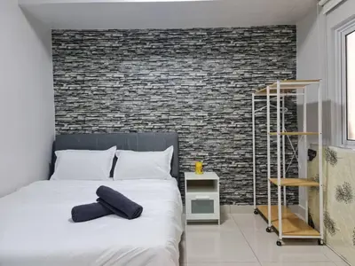 a bedroom with a large bed with a brick wall at Maritime Karpal Singh in George Town